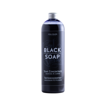 Un grand flacon noir de 500 ml étiqueté « Coal Black - Savon noir concentré » se tient debout sur fond blanc. L'étiquette, avec traductions en allemand, indique « Soap Concentrate - Soothing & Caring ».