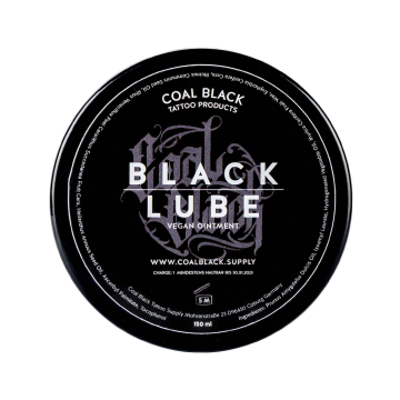 Un récipient rond noir étiqueté « Coal Black - Pommade de tatouage végane Black Lube 120 g », vu d'en haut, avec un texte blanc et gris détaillant le produit et l'entreprise.